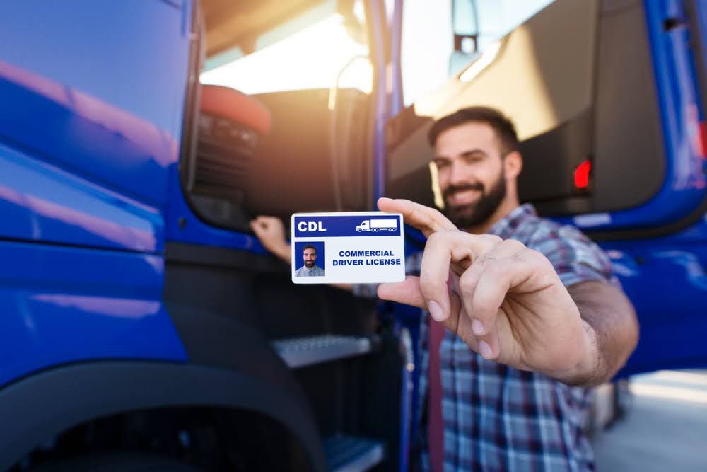Benefits of CDL license a truck driver holding his license.